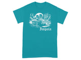Teal t-shirt featuring a white graphic of a classic Impala car in a city scene.