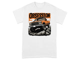 Orange pickup truck off-roading over rocks with "OBSESSION" text above.