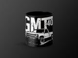 Black mug with white graphic "GMT 40" and a classic pickup truck illustration.