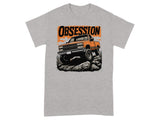 Orange lifted pickup truck climbing rocks with "OBSESSION" text.